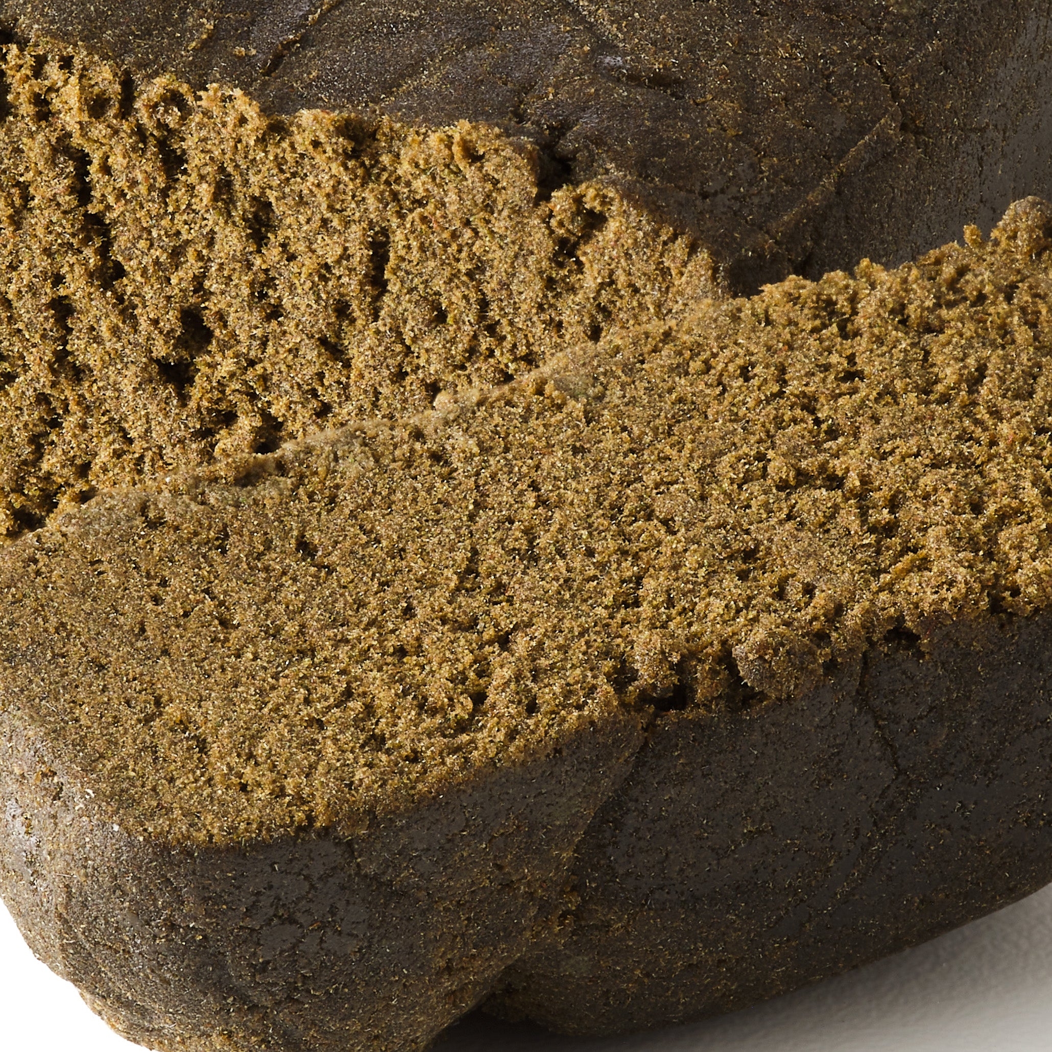 Ivory Afghan Bomb CBD hash showing dense dark hemp hash with smooth pressed finish